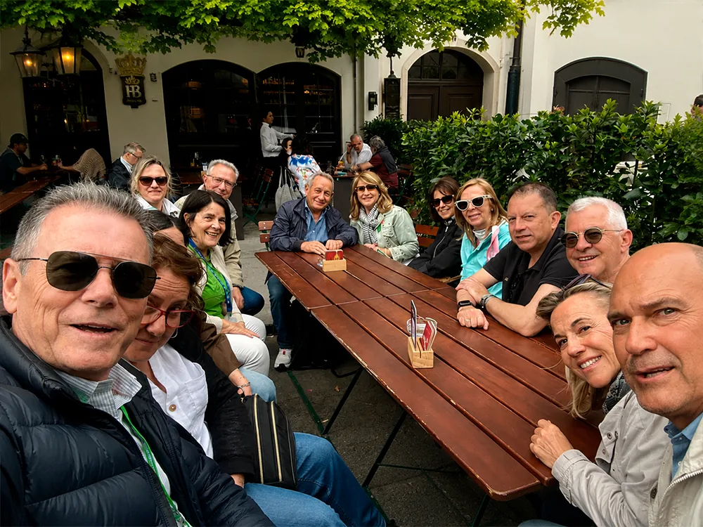 Socios de Mediavanz sentados a una mesa larga en una terraza durante un encuentro